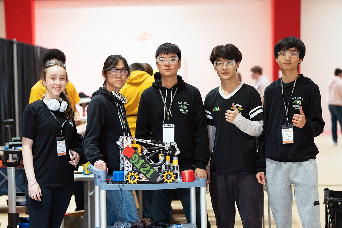 Team members posing with robot at competition