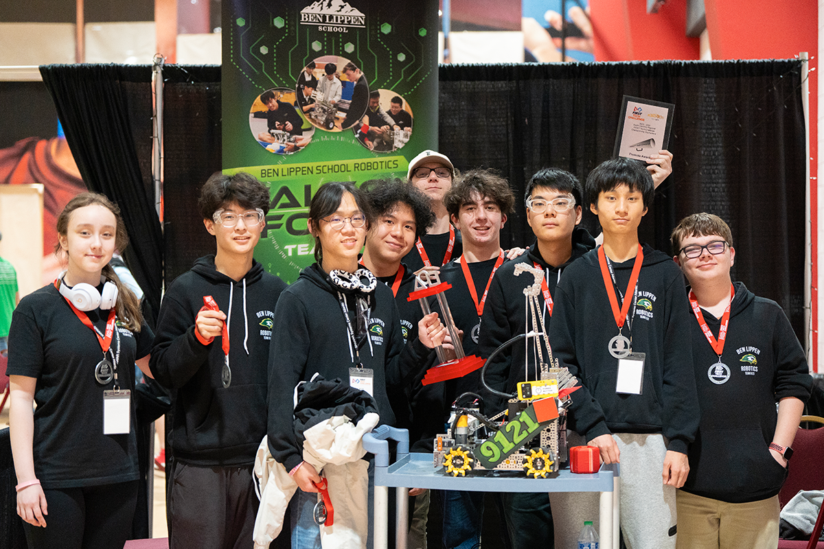 Full team group photo with robot and awards